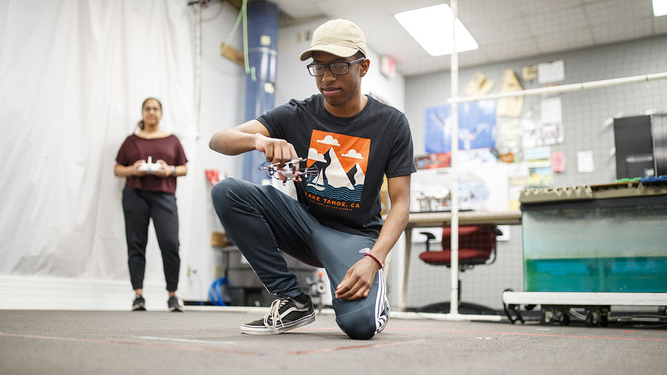 Nathan Simms, a freshman in Mechanical Engineering from Bellevue, NE, receives flight instruction  to fly a small drone in the NIMBUS lab from Siya Kunde, Phd student in Computer Science. The flying is part of the Foundational interaction Research with Drones research team under Professor Brittany Duncan.   September 25, 2019. Photo by Craig Chandler / University Communication
