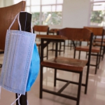 covid mask hanging on desk in classroom