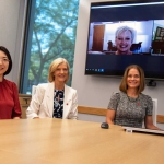 HyeonJin Yoon, Sue Sheridan and Amanda Witte at table with East Tennessee State University partners on computer screen behind them