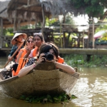 Students sitting in the bow of a boat while traveling down a reiver in Vietnam.