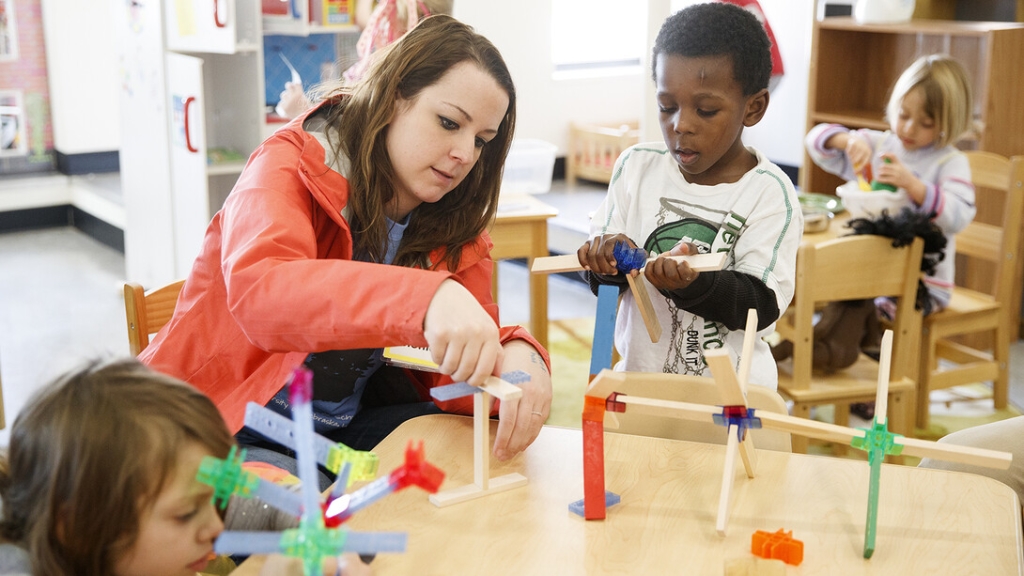 Researcher working with students in classroom