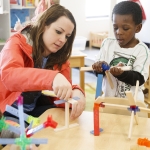 Researcher working with students in classroom